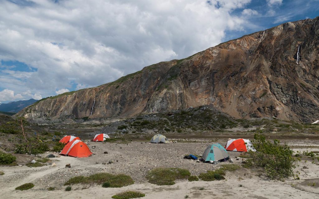 A group of tents set up in front of a mountain.