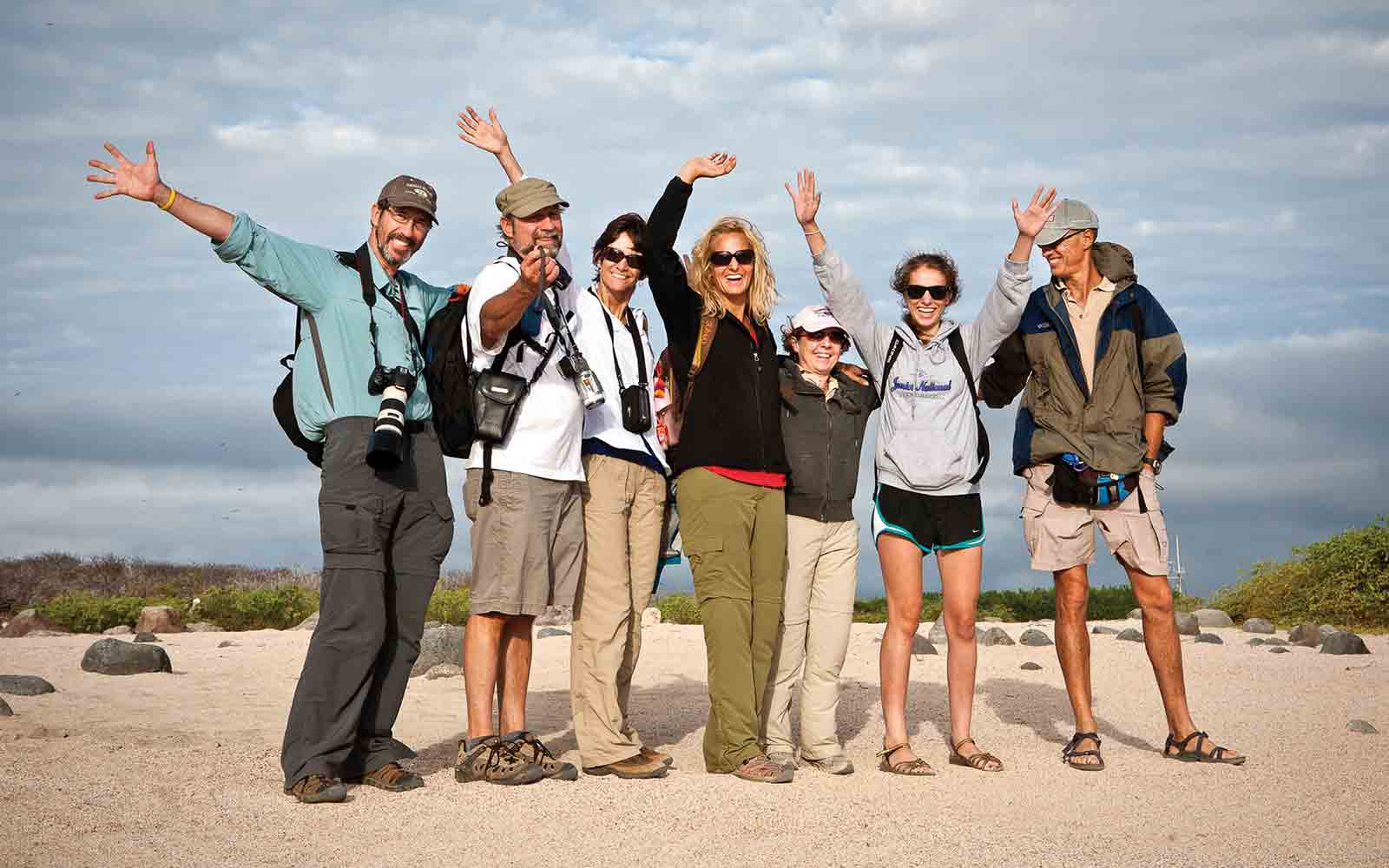 A group of people posing for a photo on the beach.