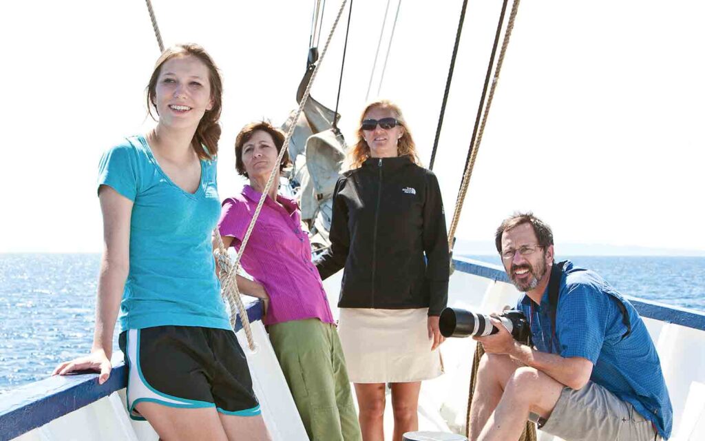 A group of people posing on the deck of a boat.