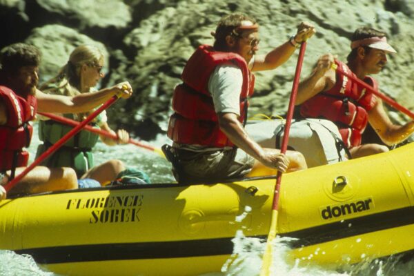 River rafting enthusiasts enjoying a thrilling adventure in a yellow raft.