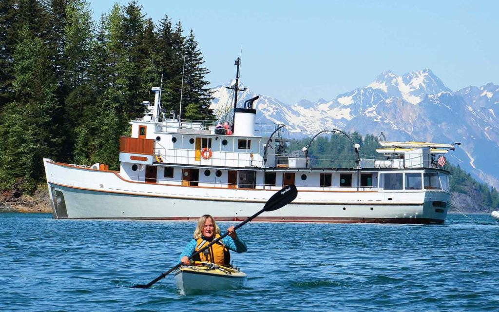 A woman is enjoying an adventure cruise while paddling a kayak in the water.