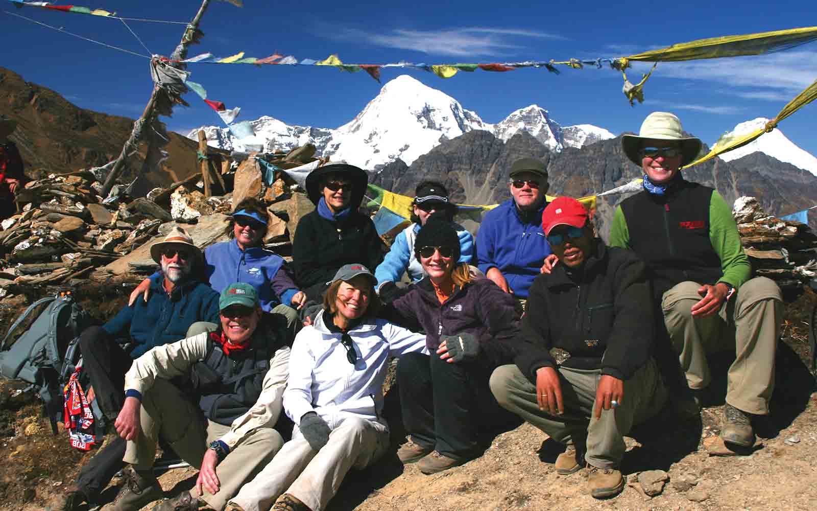 A group of people posing for a photo in front of mountains.