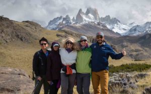 A group of people posing for a photo in front of a mountain during their active adventure in Patagonia.
