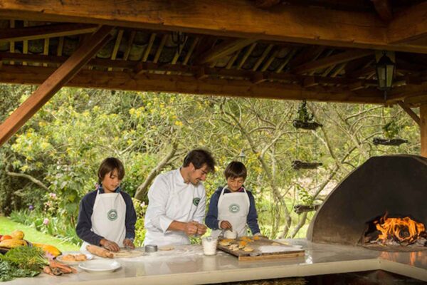 A group of people cooking in an outdoor kitchen.