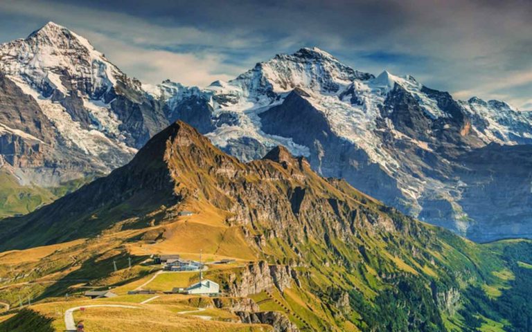 A breathtaking view of a the Alps mountains in  overlooking a little walking village in Switzerland