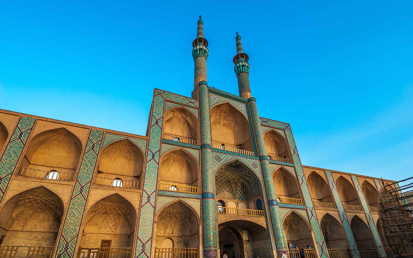 A mosque with two minarets and a blue sky.