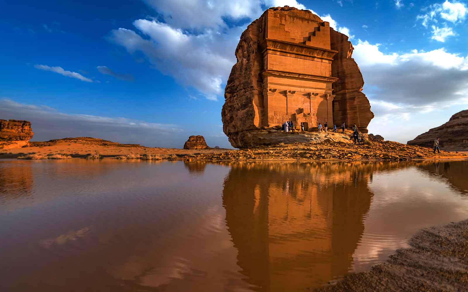 A rock formation with a reflection in the water.