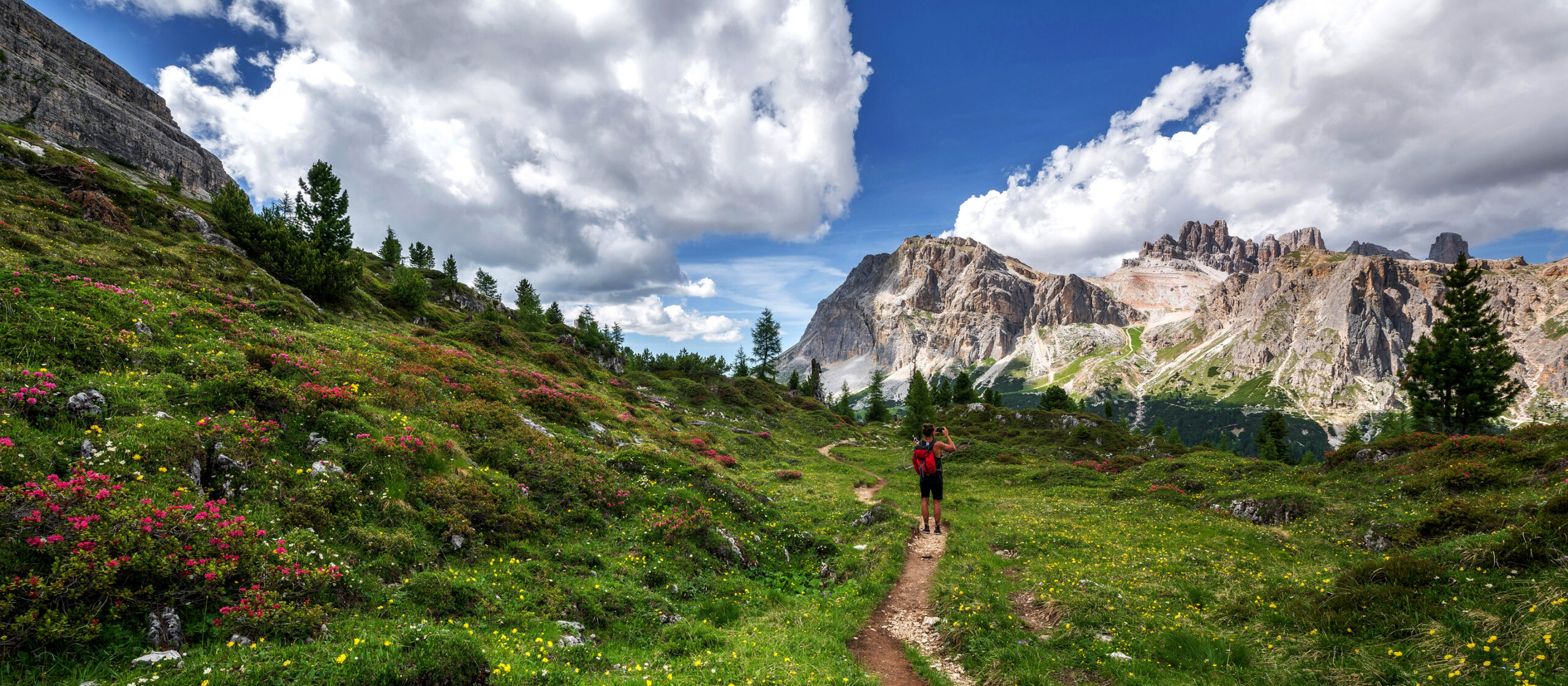 A man is walking through the mountains in the dolomites.
