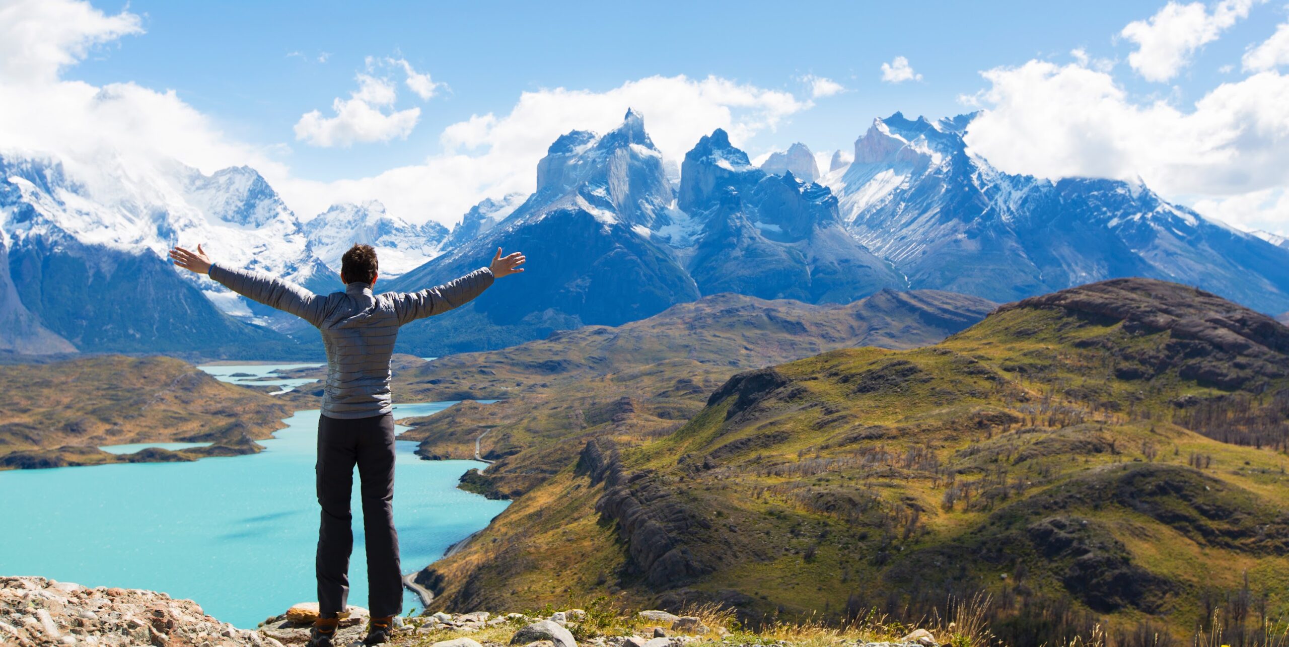 A man standing on top of a mountain with his arms outstretched.