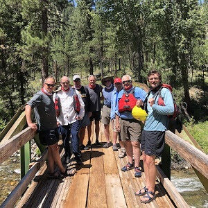 A group of people standing on a wooden bridge.