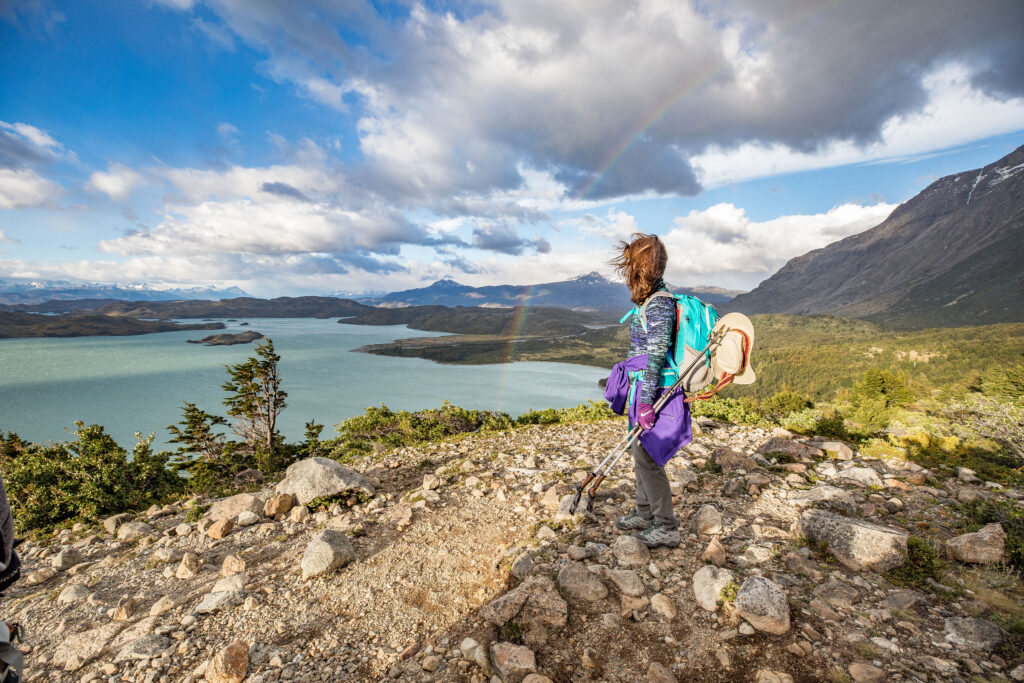 Solo hiker in hiking gear looking at the water in Patagonia