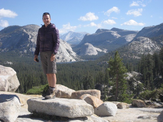 A woman standing on top of rocks in yosemite national park.