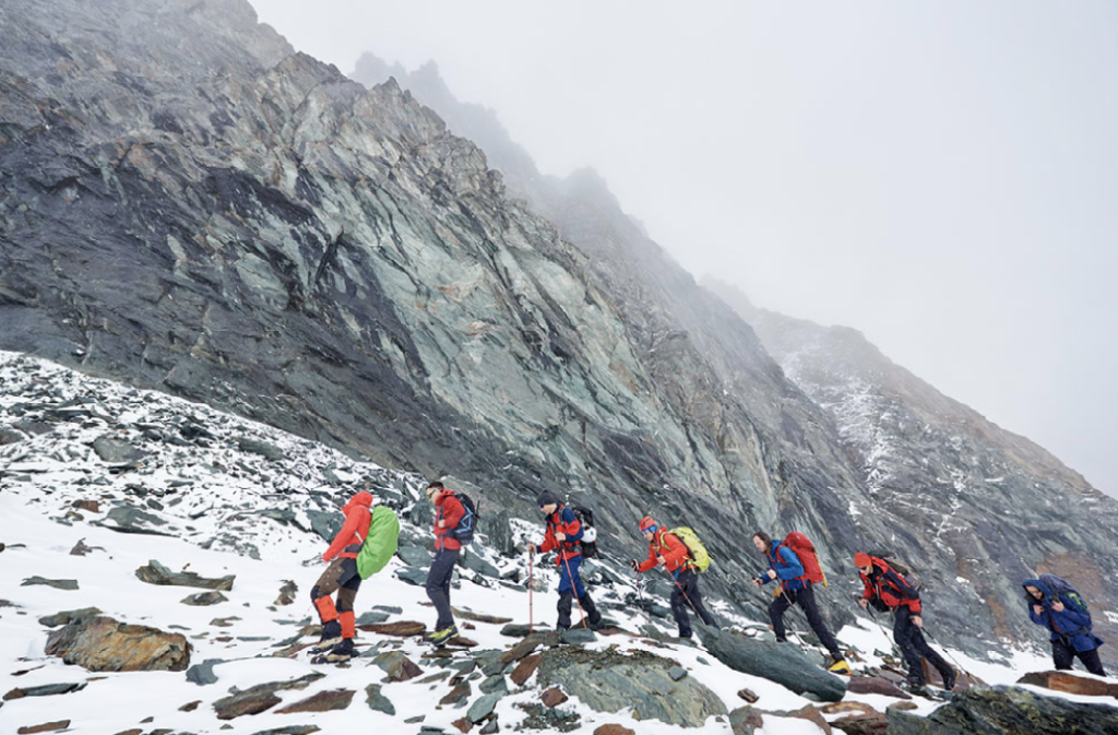 Group of trekkers with day packs in the glacial wilderness 