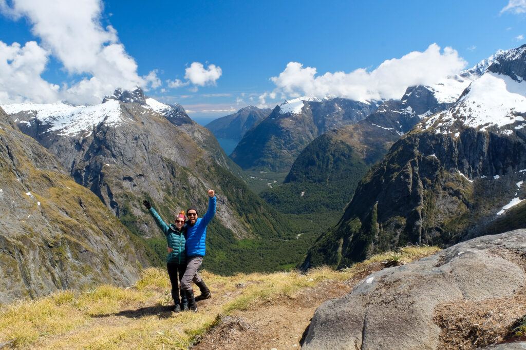 Two people male and female standing on top of a mountain in new zealand, europe