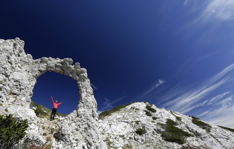 Solo hiker in pink hiking gear exploring the Via Dinarica Alps in Slovenia, Europe