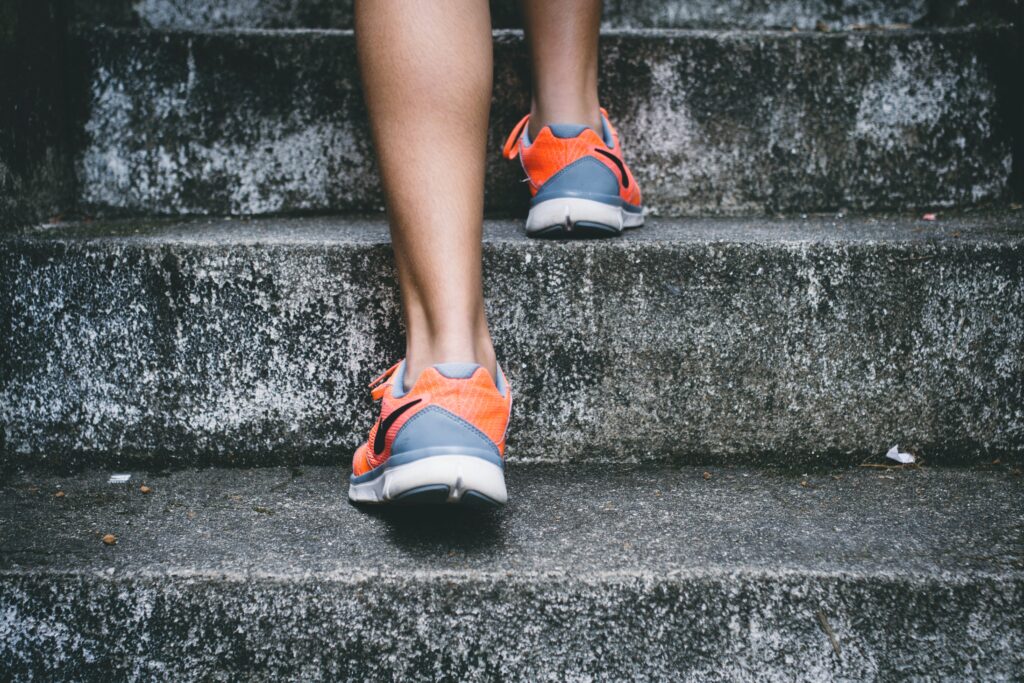 man with hiking shoes going up a flight of stairs