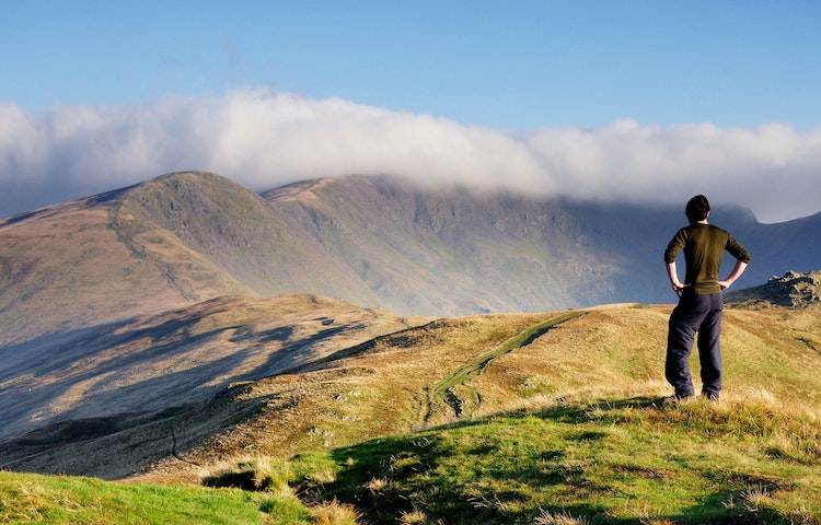 Hiker looking at mountainous trail in England during a guided tour
