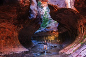 Hiker wading in the Virgin River Narrows in Zion National Park, Utah