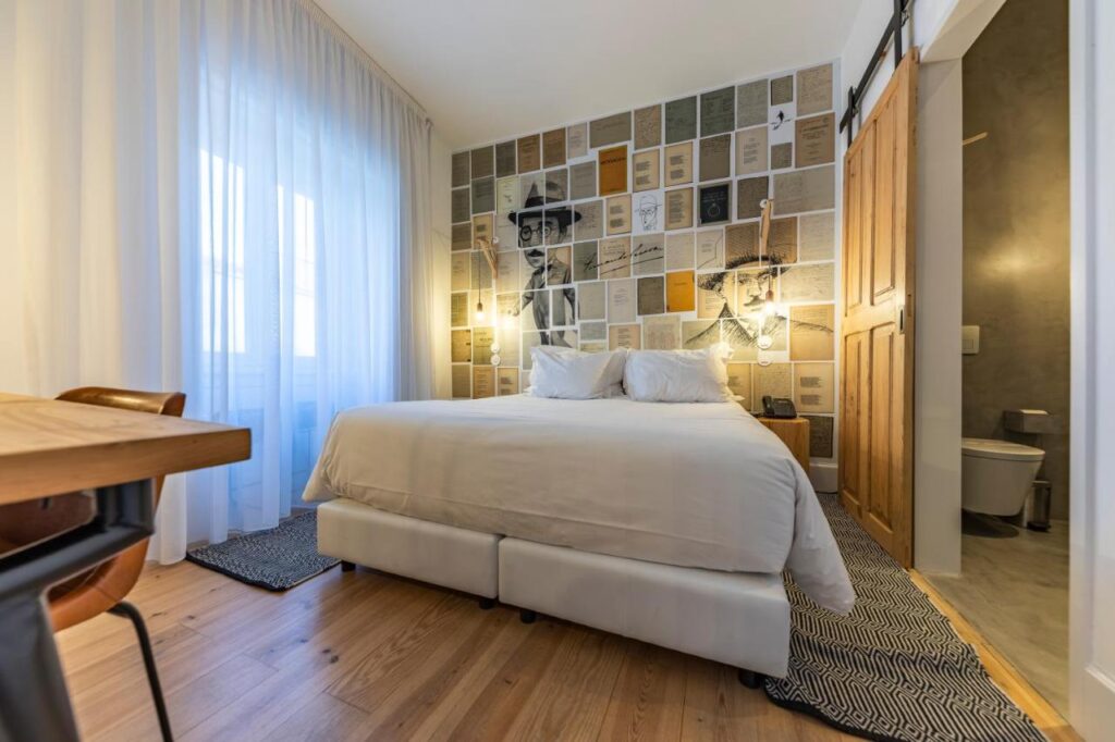 Artist paintings covering a bedroom wall in Portugal's oldest hotel, the Sapientia