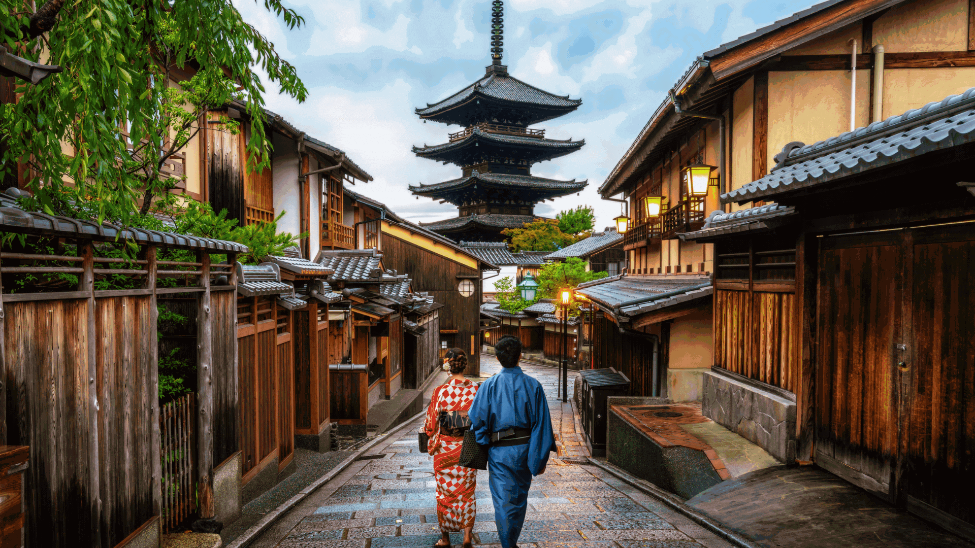 In the enchanting alleyways of Japan, a couple strolls hand in hand with a picturesque pagoda in the background.