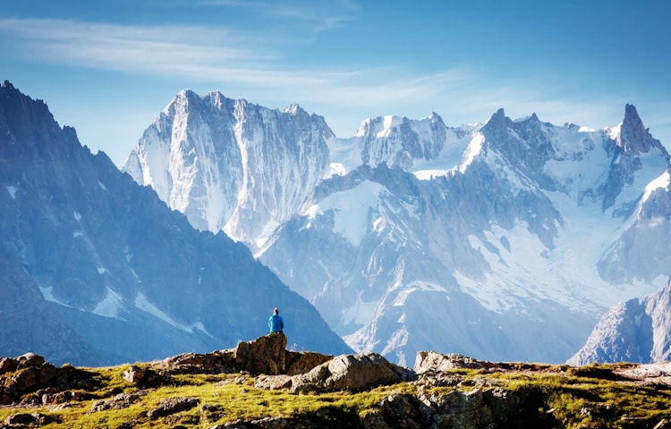 solo hiker resting in front of the highest and most iconic peak of Europe, Mont Blanc