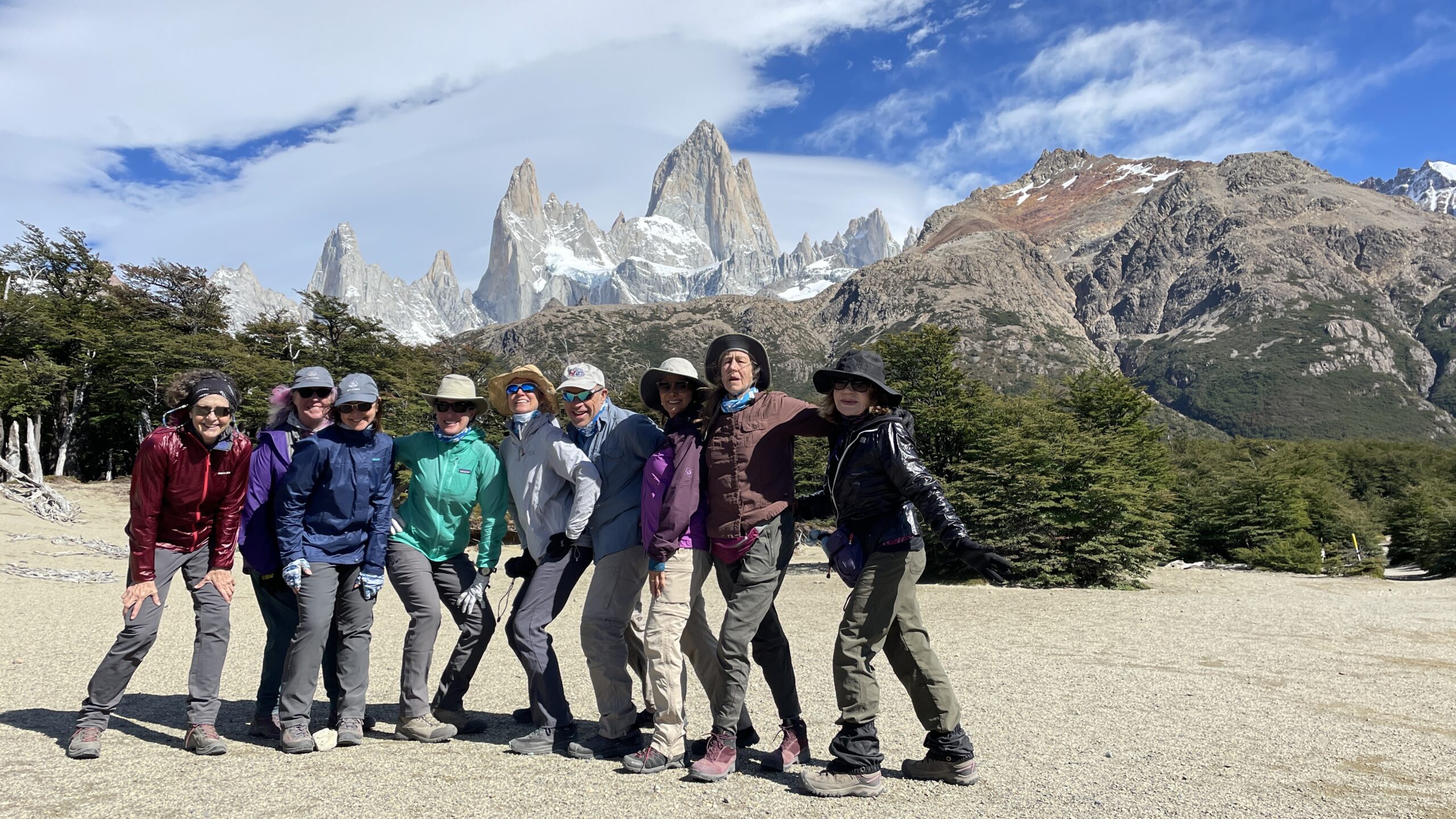 A group of people posing for a photo in front of mountains during their Patagonia hike.