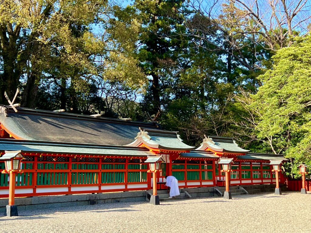 Travelers bowing respectfully at an ancient temple along the Kumano Kodo hiking trail