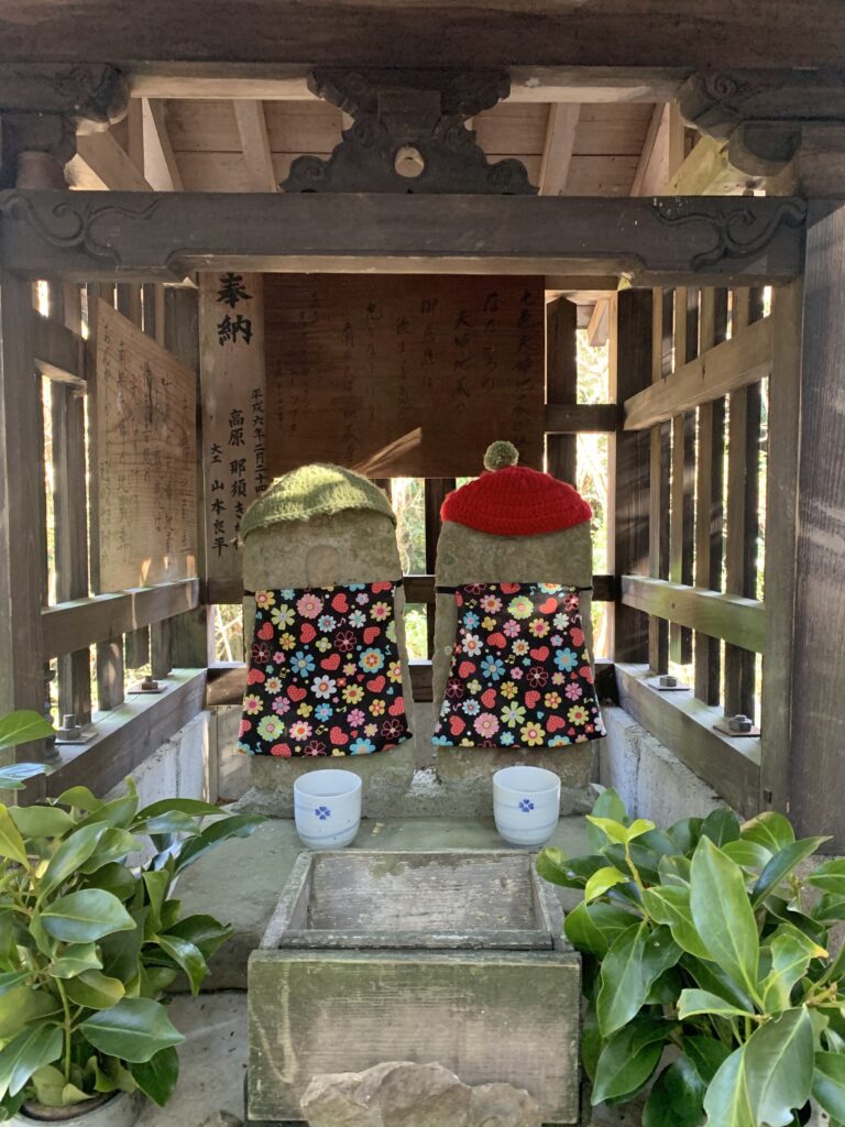 Jizo child-deities adorning a small stone tower along the Kumano Kodo trail in Japan