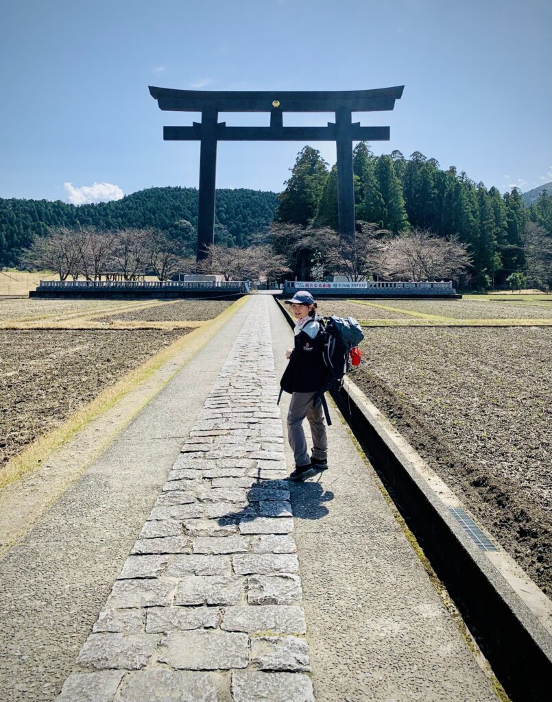 Traveler exploring the original Hongu Taisha Shrine in Oyunohara - home to the world's largest Torri gate