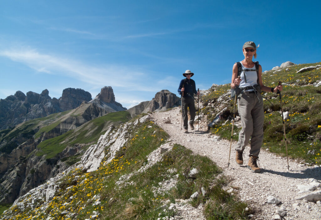 Travelers hiking on a trail along the Dolomite's dramatic, craggy mountains - a hiker's dream