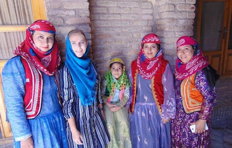 Iranian women adorned in traditional clothes smiling in Iran