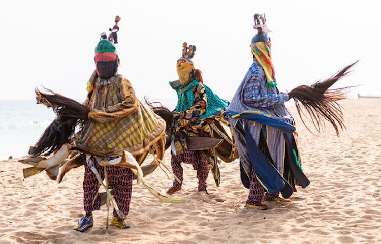 Traditional masked voodoo dancers performing a ritual in West Africa