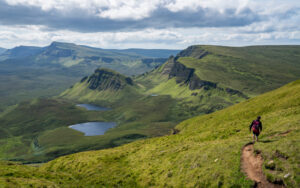 Hiker trekking the great green landscape of Scotland Western Isles