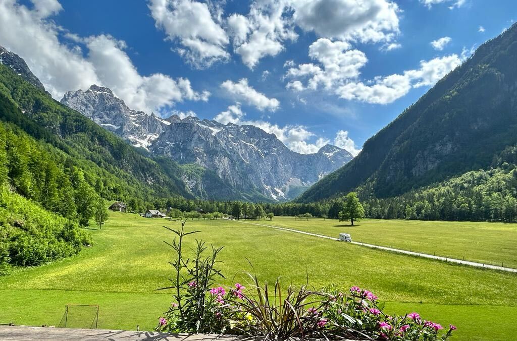 Group of hikers trekking the great green Raduha Mountain Ridge with a magnificent backdrop of the Dinaric Alps in Slovenia