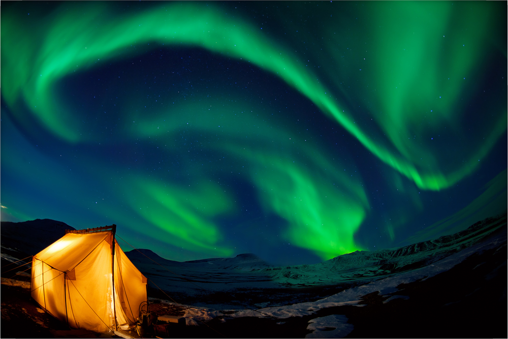 Camping in the north with the northern lights overhead (Aurora Borealis)