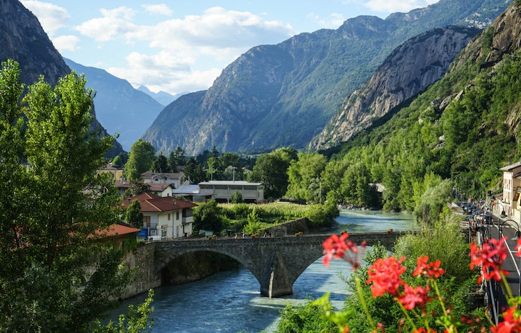 A river runs through a village in the mountains.