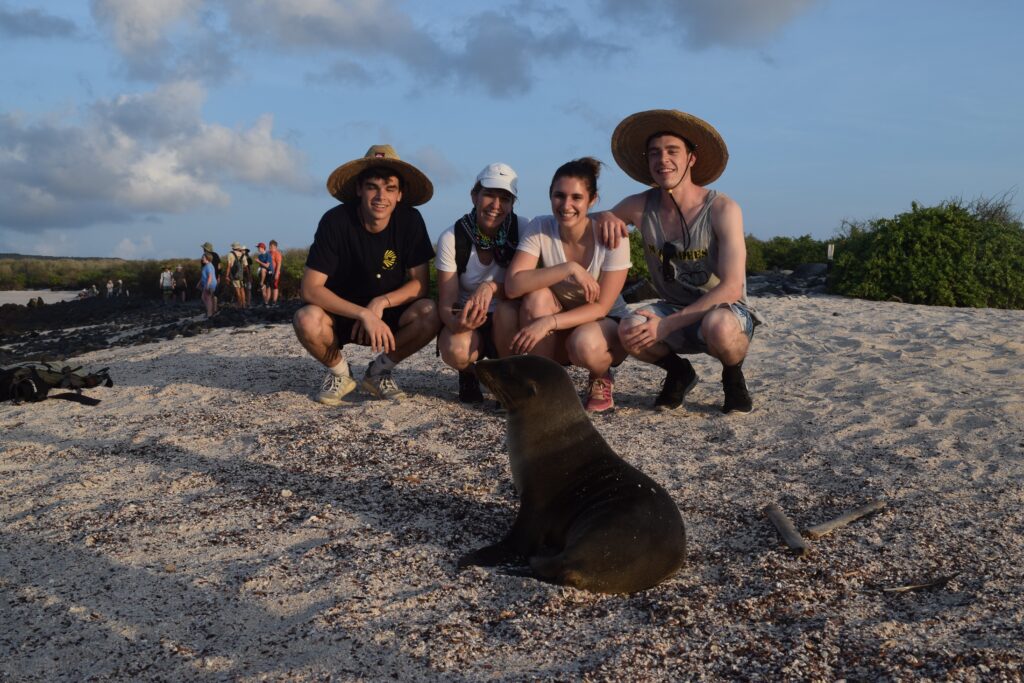 two girls and two guys staring at a Galapagos seal on the Santa Cruz island of the Galapagos in Ecuador