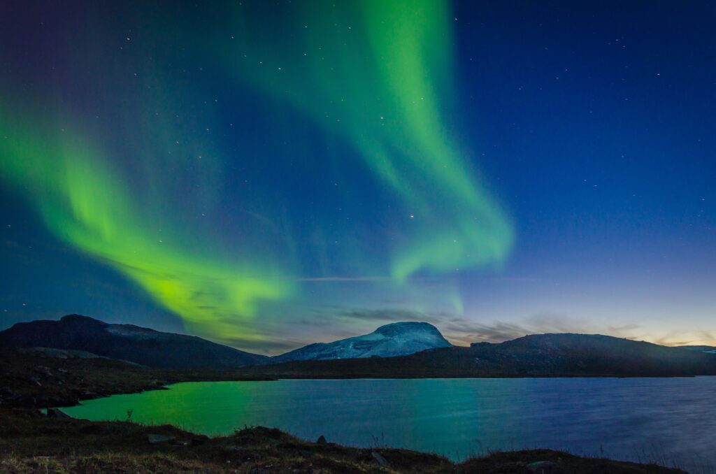 Aurora burealis sighting in Sweden near a mountain with a lake
