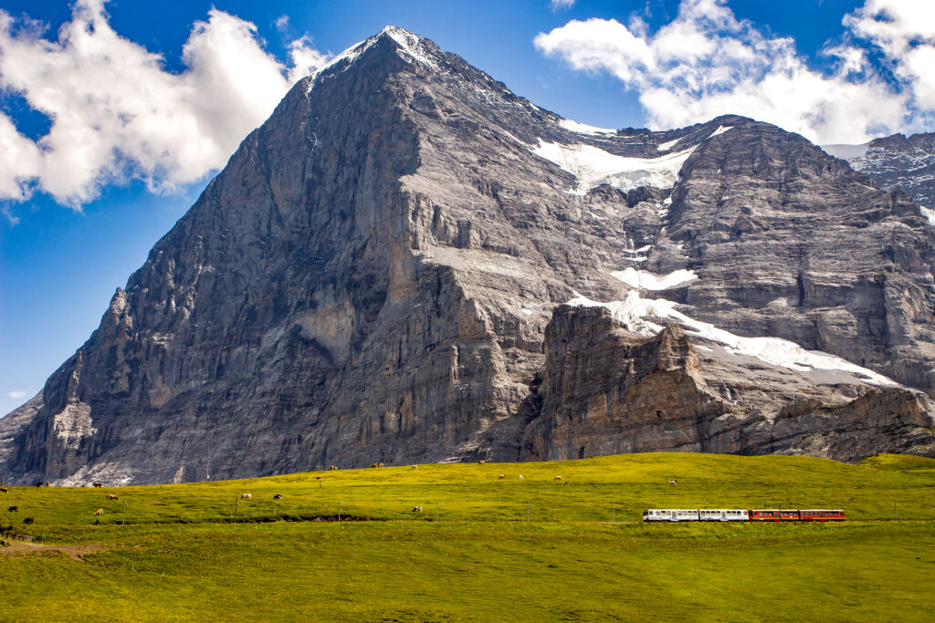 Majestic north face of Eiger mountain (3.967m - 13.015ft) and train to Jungfraujoch in the Bernese Alps in summer. Kleine Scheidegg Bernese Oberland Switzerland.