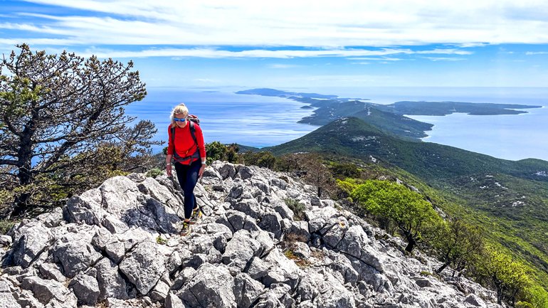 solo female hiker in red hiking rugged trails of the best Croatia hiking tour