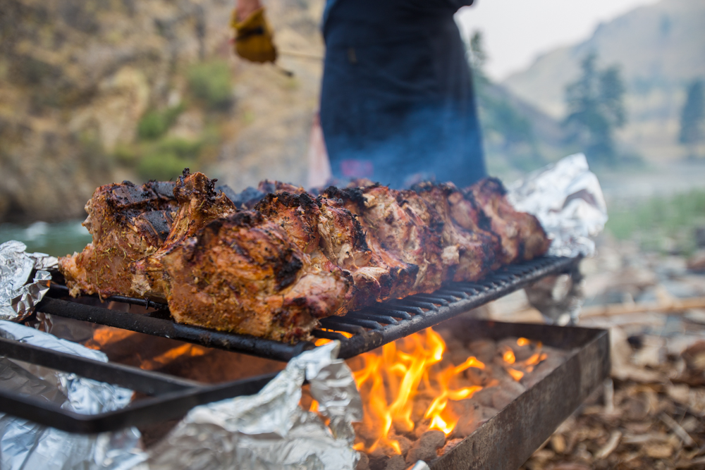 grilling meat during a daytime meal time with group at the Middle Fork of the Salmon River in Idaho, North America