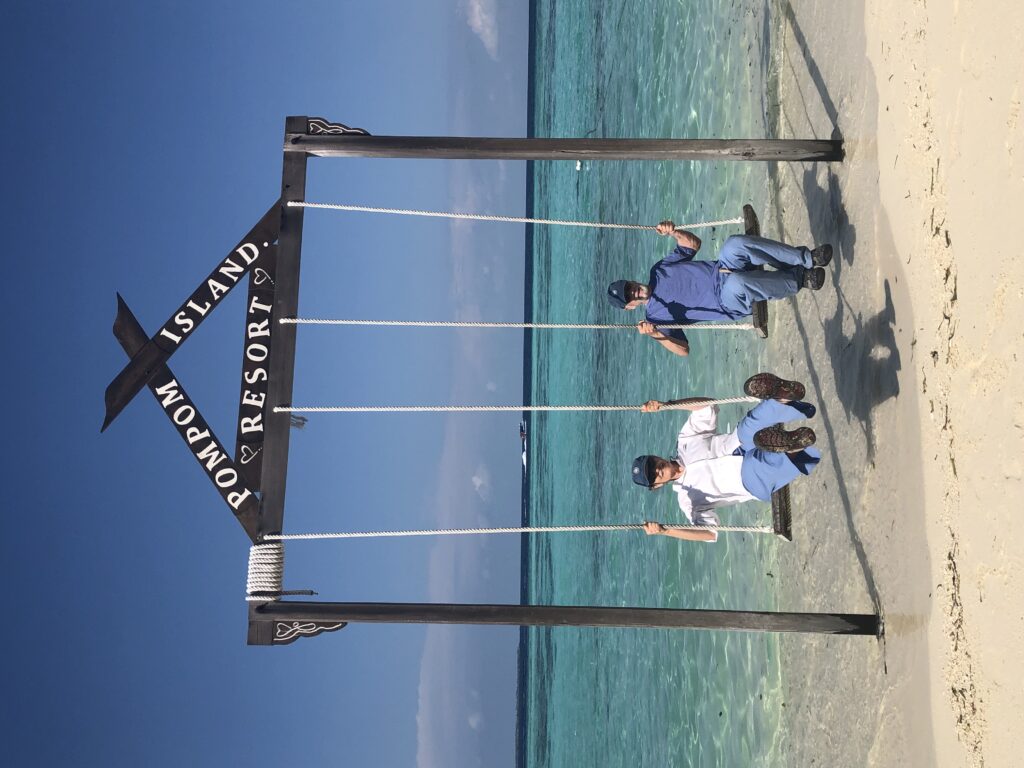 a couple of travelers having fun swinging on giant swing in Mataking Island known for its sandy beach and coral reefs in Borneo, Asia