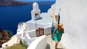 female traveler in green dress in Santorini near Aegan Sea in Greece, Europe
