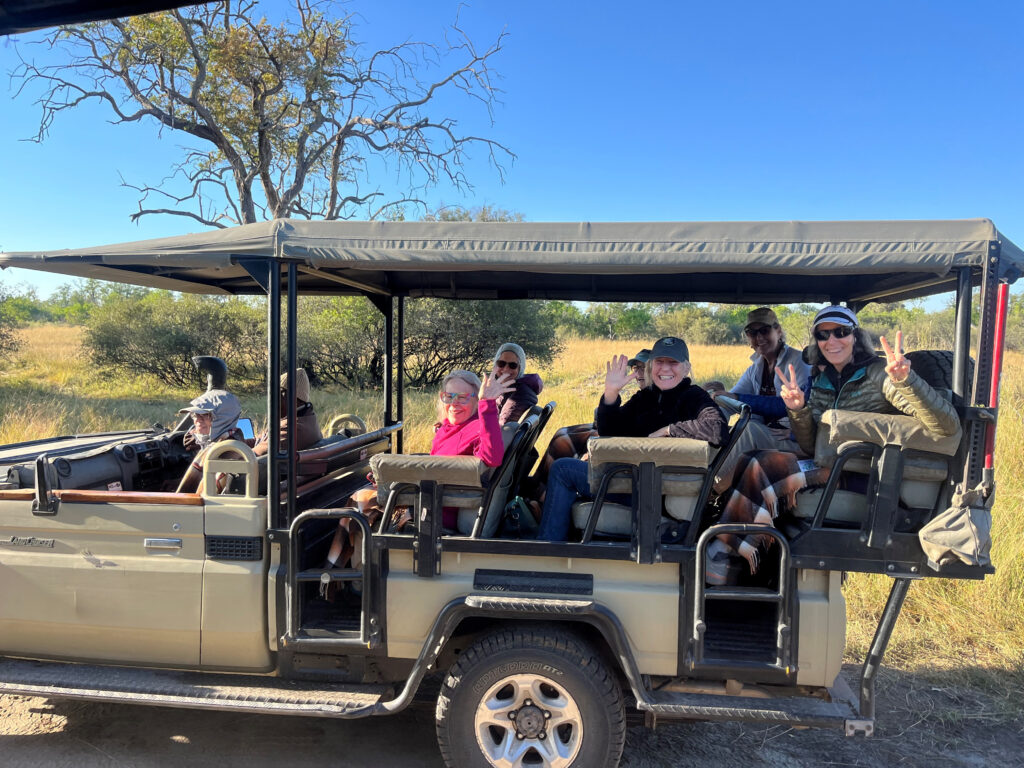 travelers on a game drive in Botswana, Africa, with guide and group