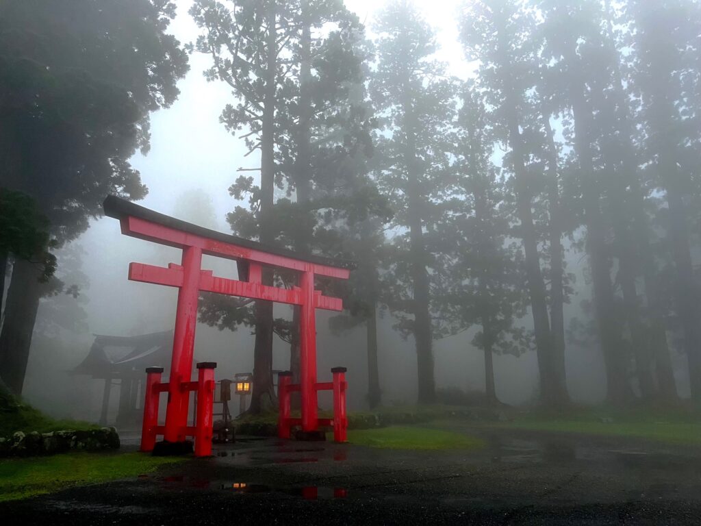 seeing torii red gate in fog on ancient trail path in Japan Lake and Mountains