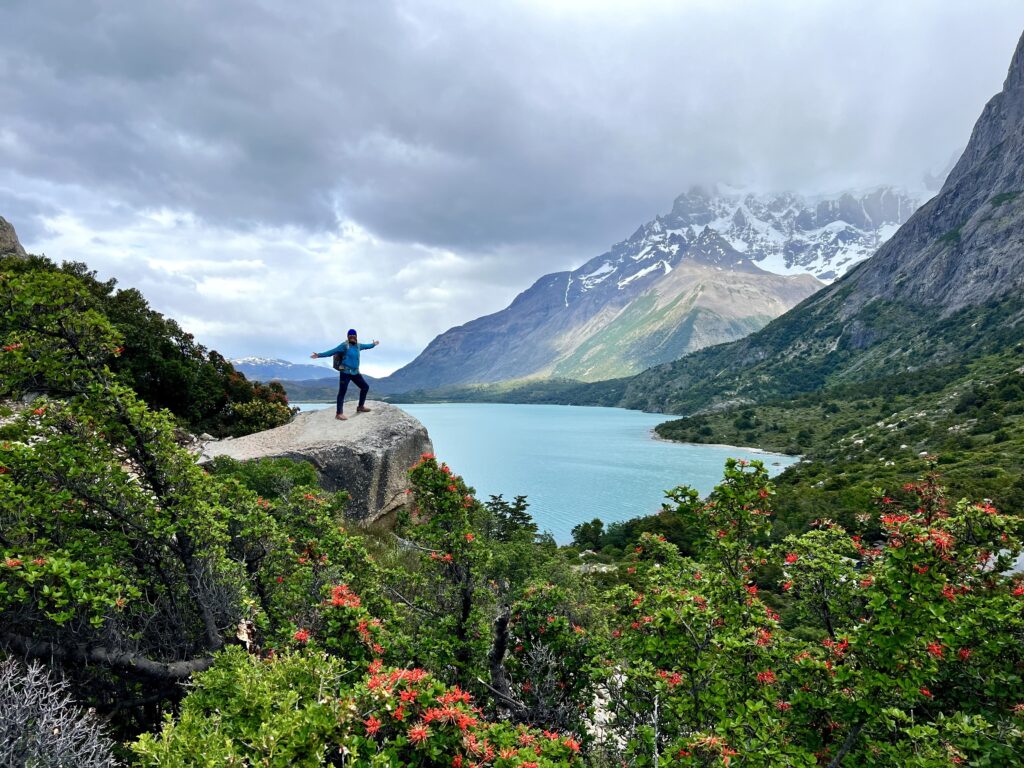 hiker on top of mountain near lake landscapes in Torres del Paine in Patagonia