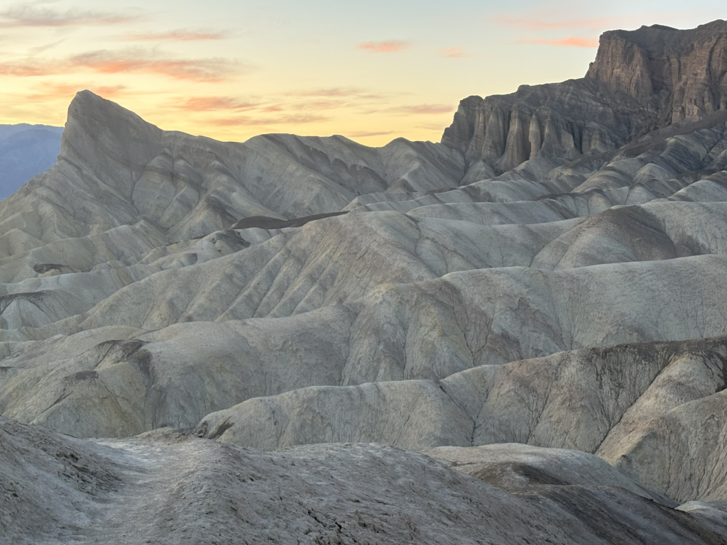 witness sunset views looking down from Zabriskie Point to Manly Beacon rock formation in Death Valley National Park in California