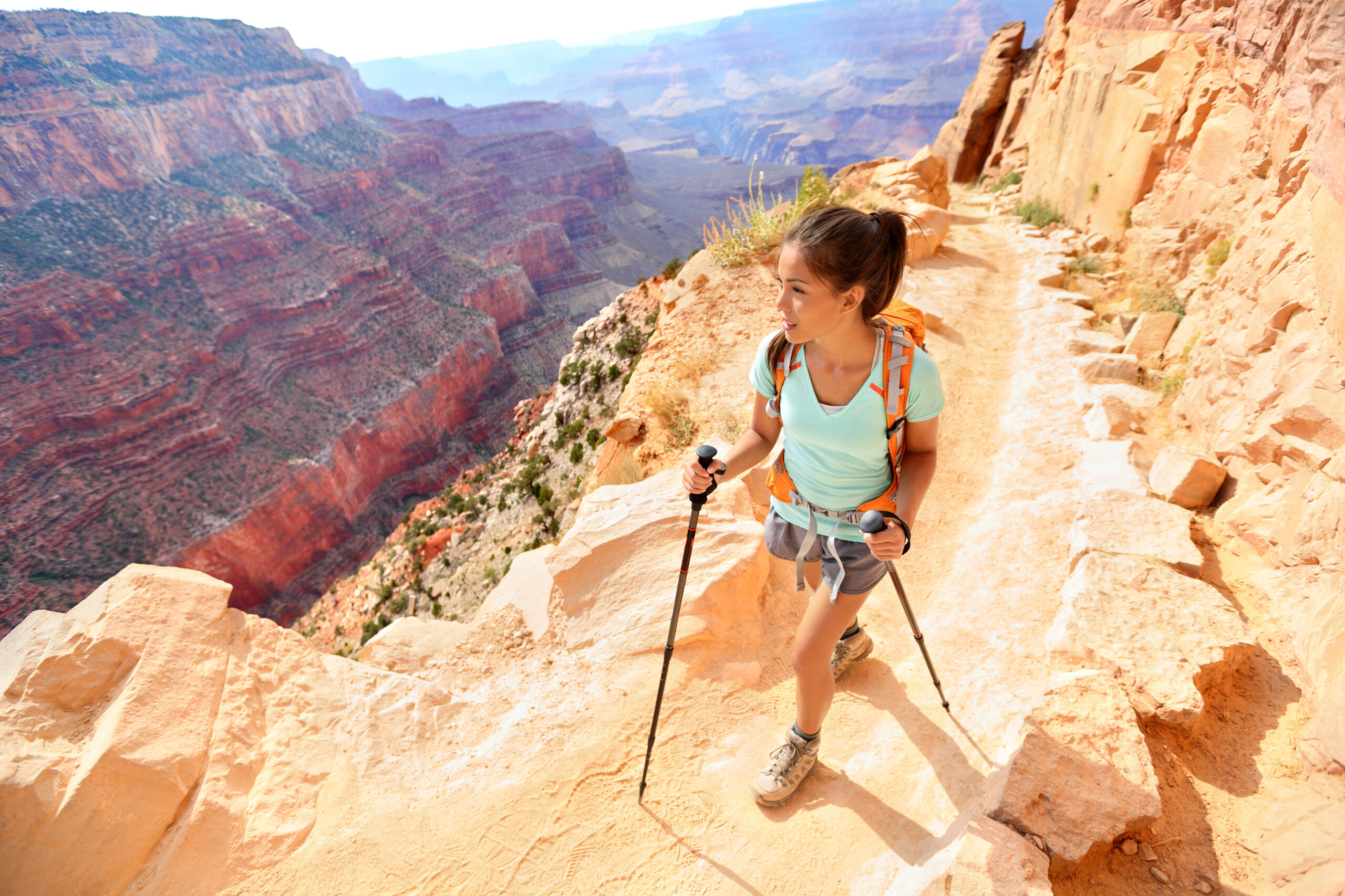 hiker woman hiking in grand canyon walking with hiking poles